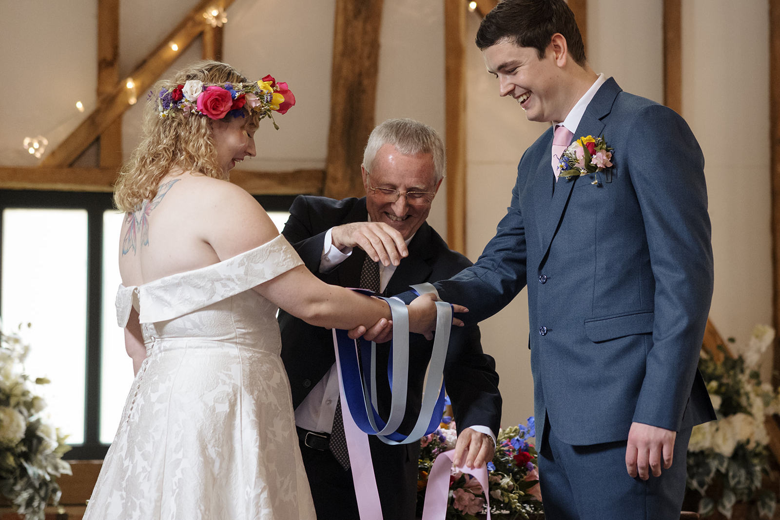 Maya & Sam’s High House Wedding 01-06-2024 1 A Civil Weddings handfasting ritual held in Essex barn beneath timber beams and fairy lights.