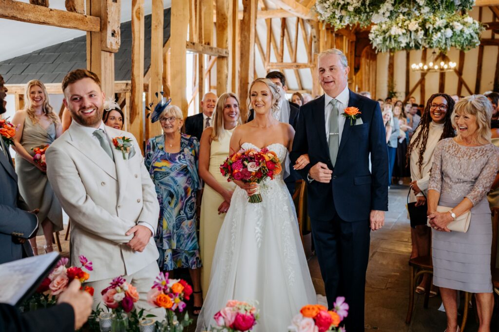A joyful moment during a wedding ceremony, with the couple and guests smiling and laughing together.