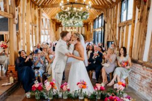 Couple kisses at the altar moments after being pronounced husband and wife — a joyful, heartfelt moment.