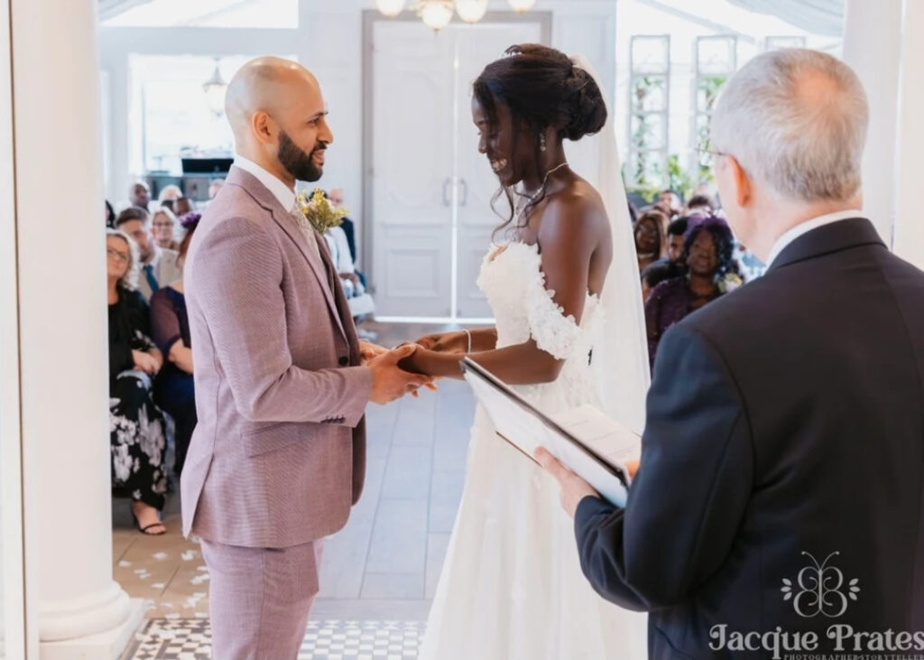 Bride and groom sharing a joyful moment during their ceremony in a bright wedding room.