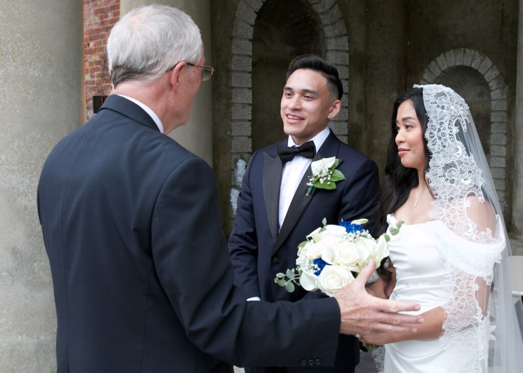 Bride and groom speaking with their celebrant during their ceremony at Wotton Hall.